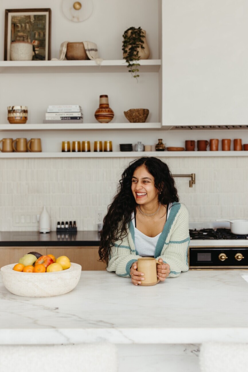 Woman holding mug in kitchen_l-glutamine and gut health