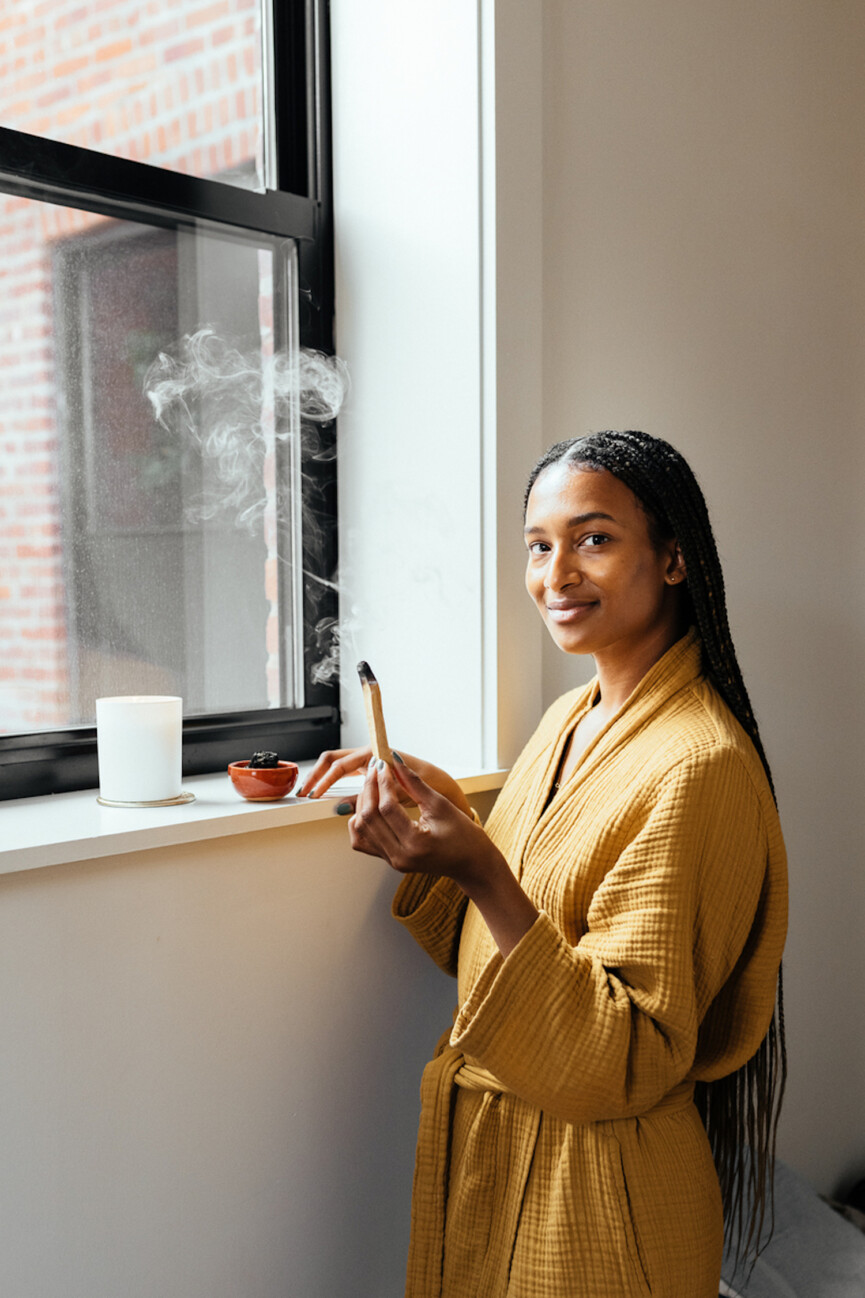 Woman lighting palo santo.