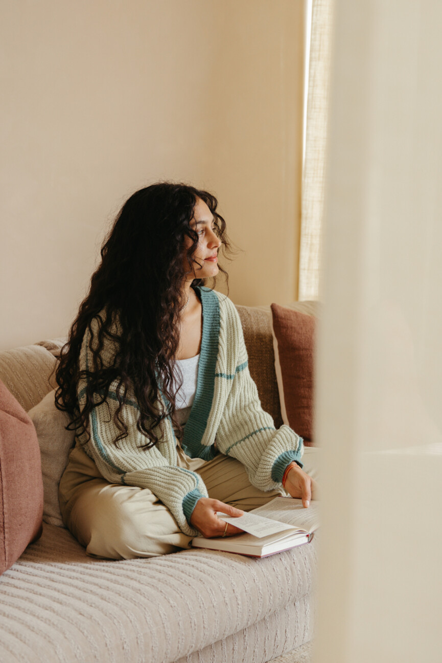 Woman reading book on couch.