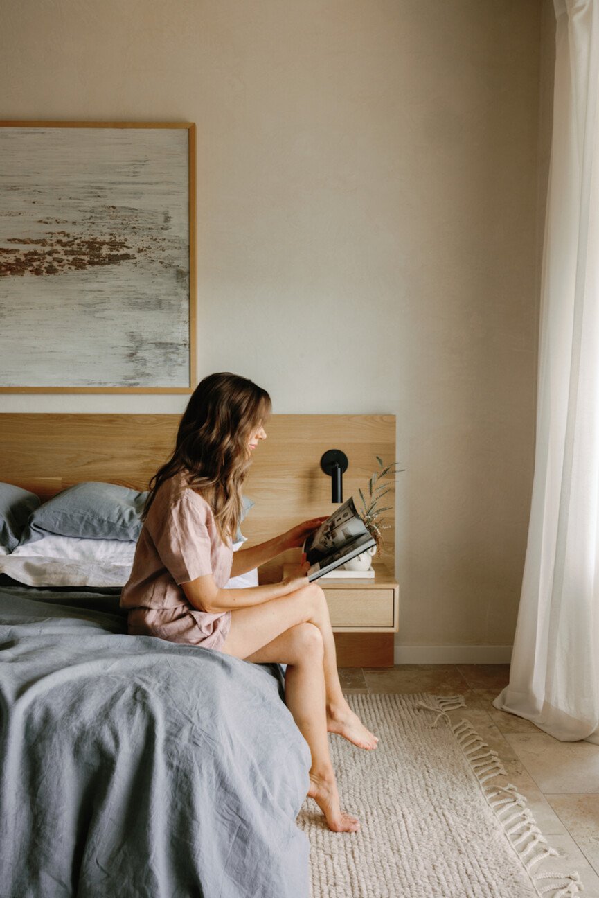 Camille Styles reading on bed.