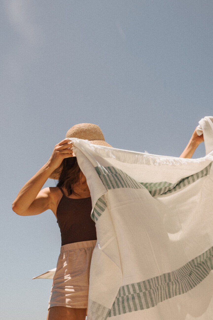Woman shaking beach towel.