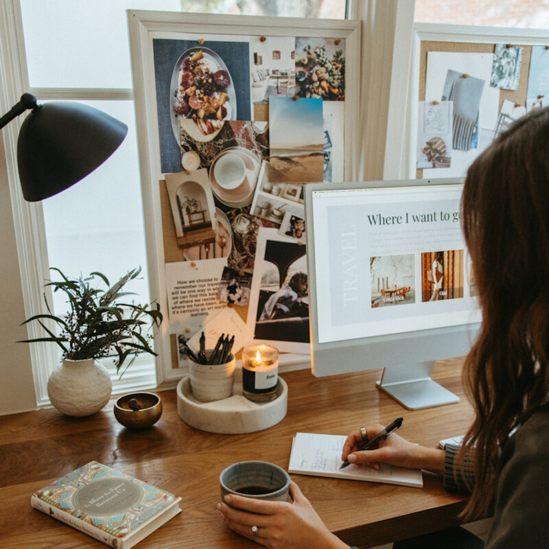 Woman writing list at desk.