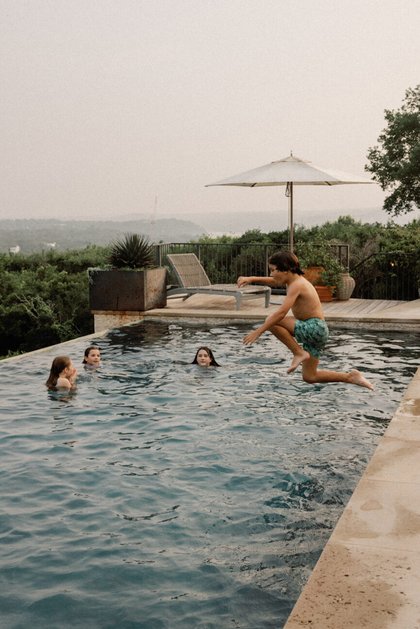 Kids jumping into pool on a hot summer day.