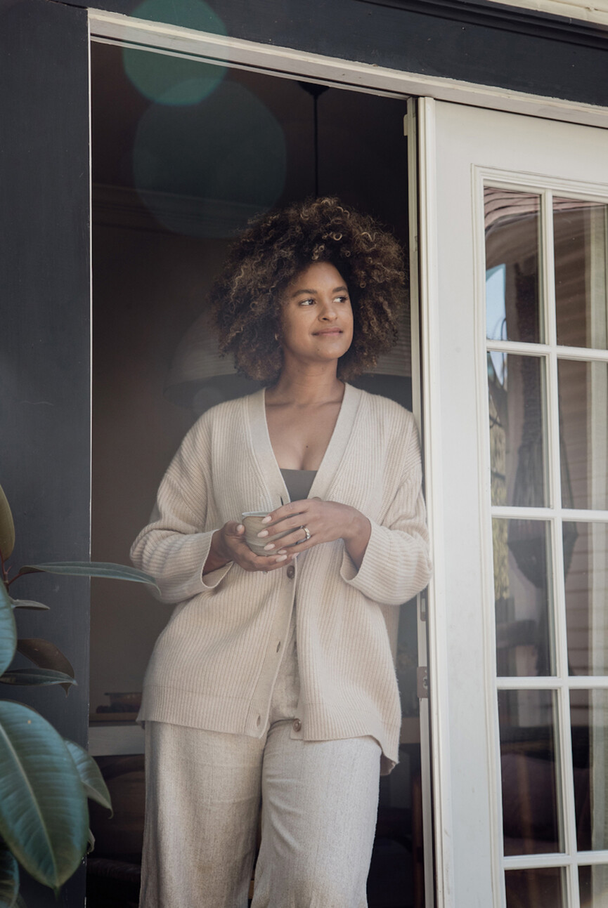 Woman wearing loungewear drinking coffee.