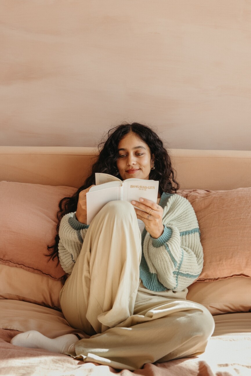 woman jouranling and reading in bed