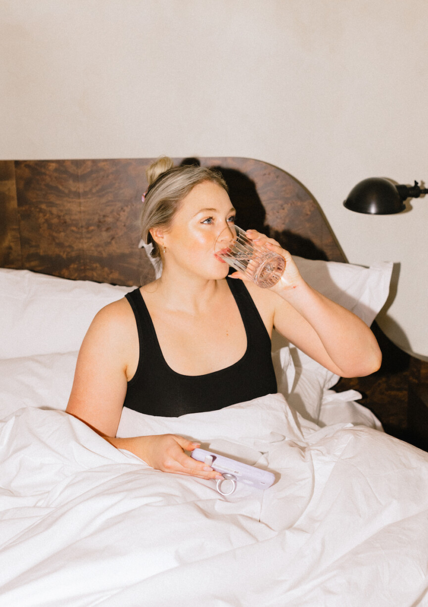 woman drinking water in bed