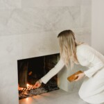 Woman lighting fireplace