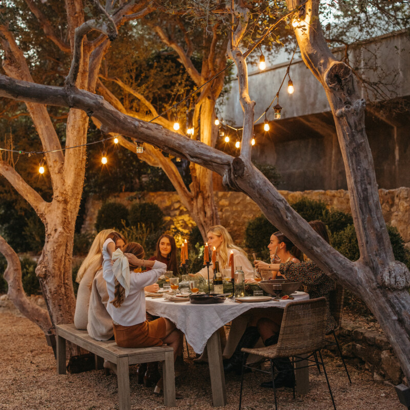 Friends at holiday dinner party around table at night