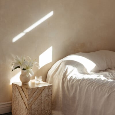 sunlight on a wall behind a minimal bed
