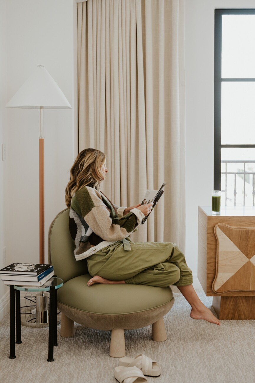 woman reading magazine in chair