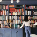 Woman taking book off a shelf.