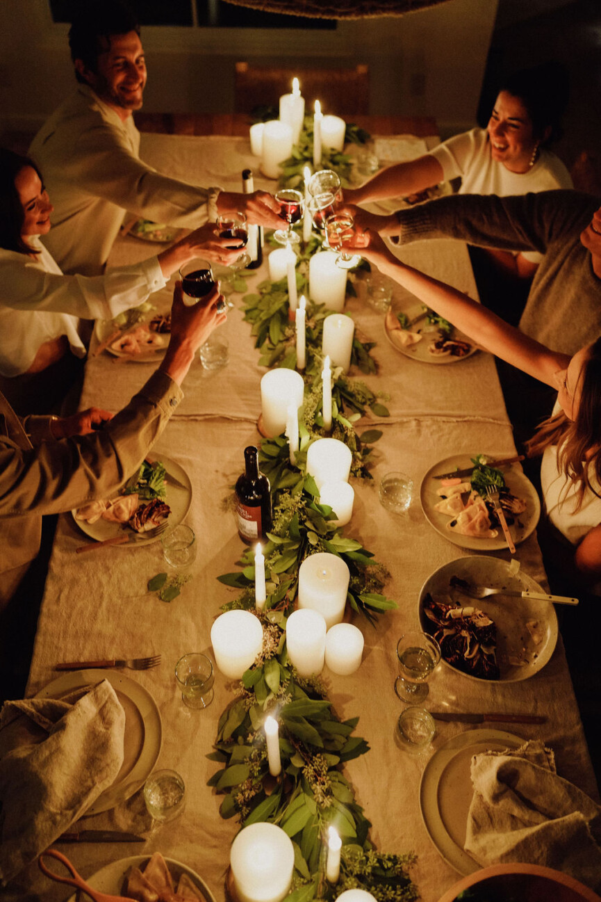 holiday candlelit dinner party cheers over table
