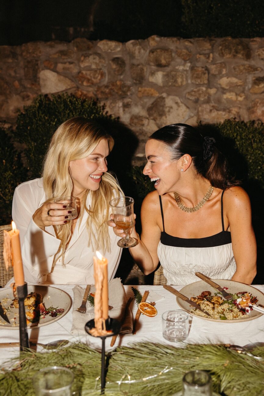 Women communicating confidently at dinner party.