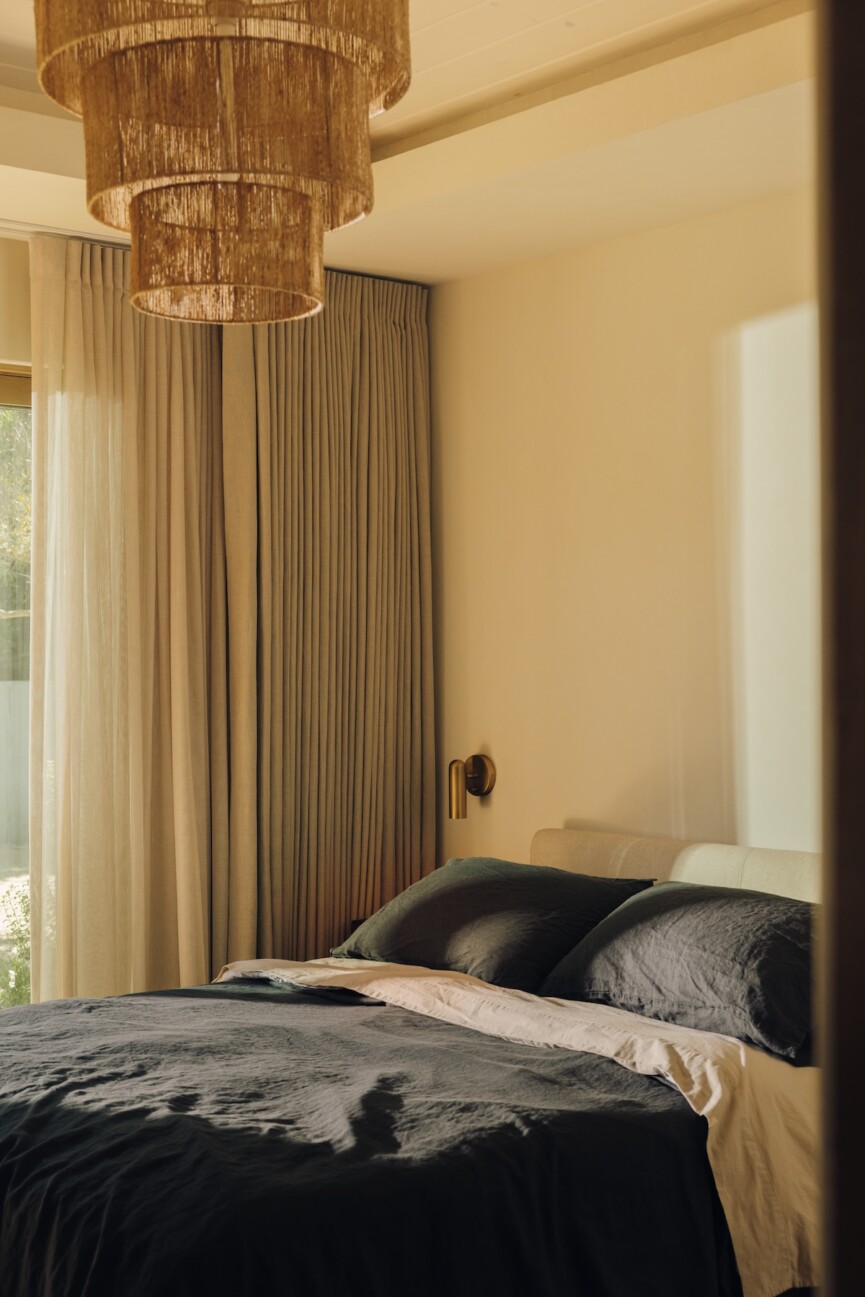 Floor-to-ceiling taupe curtains adding softness and privacy to Camille Styles’ Malibu bedroom.